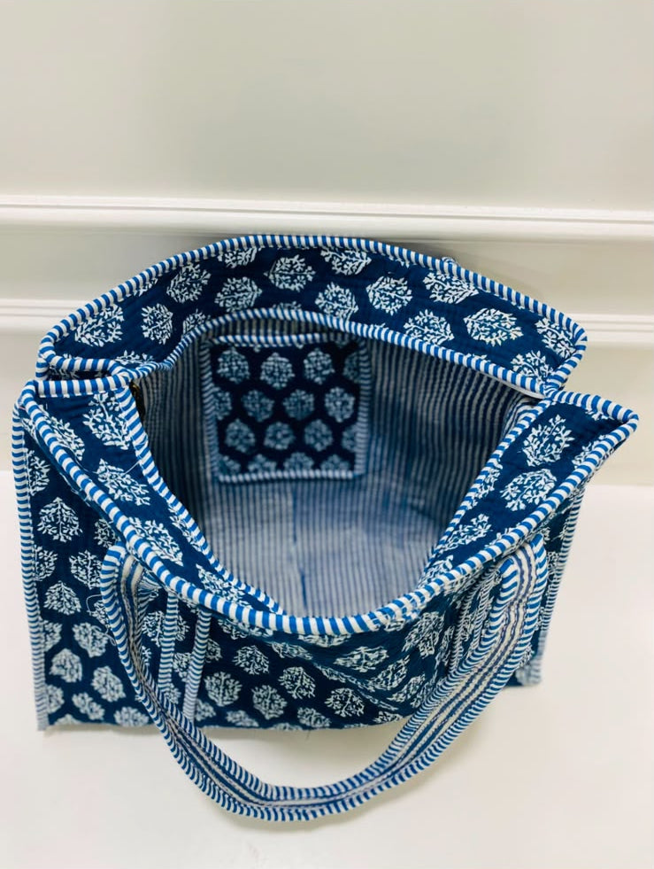 A blue and white indigo patterned fabric tote bag with matching handles, shown open against a plain light background.